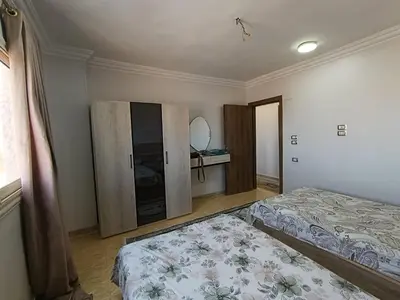 a bedroom with two beds and a mirror at 3 Bedroom in Lotus in Naj‘ al Maḩaţţah