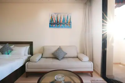 a living room with a couch and a glass table at Tranquil Terrace Studio at Ancient Sands in Hurghada