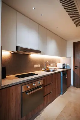 a large kitchen with wooden cabinets and a sink at Tranquil Terrace Studio at Ancient Sands in Hurghada