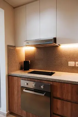 a kitchen with wooden cabinets and a stove top oven at Tranquil Terrace Studio at Ancient Sands in Hurghada