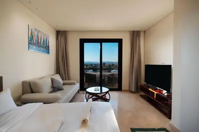 a living room with a couch and a tv at Tranquil Terrace Studio at Ancient Sands in Hurghada