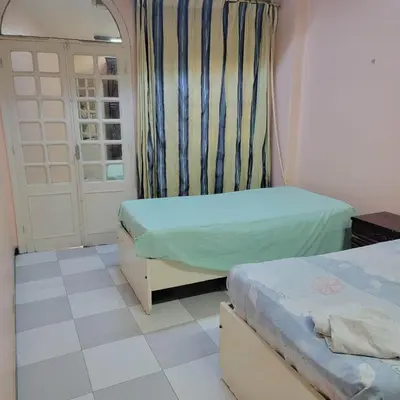 a small room with two beds and a door at OS & MA Luxor APT in Luxor