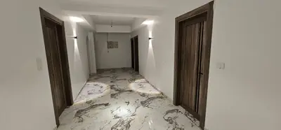an empty hallway with two doors and a marble floor at Sea view Penthouse sea front city center 11 in Hurghada