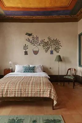 a bedroom with a bed with plants on the wall at Beit Felfel in Esna