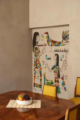 a table with a plate of fruit and a painting on the wall at Beit Felfel in Esna