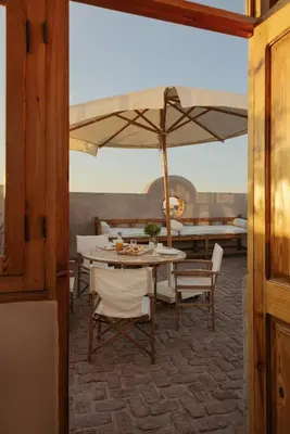 a dining room with a table and an umbrella at Beit Felfel in Esna