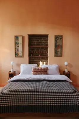 a bedroom with a large bed with two lamps at Beit Felfel in Esna