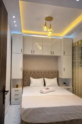 a bedroom with a large bed with white cabinets at Luxury Sea View Apt near Beach - 2 Pools - Balcony in Hurghada