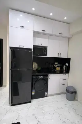 a kitchen with a black refrigerator and a microwave at Luxury Sea View Apt near Beach - 2 Pools - Balcony in Hurghada