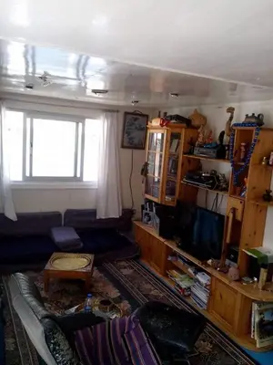a living room with a couch and a television at Nile Dream Yacht in Jazīrat Salūjah