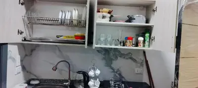 a kitchen with a sink and a cabinet with bottles at Gamal in Hurghada