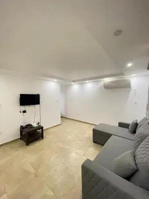 a living room with a couch and a tv at Sea-Front Selena Bay Resort Apartment in Hurghada