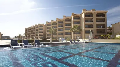 a swimming pool with chairs and a hotel at Sea-Front Selena Bay Resort Apartment in Hurghada