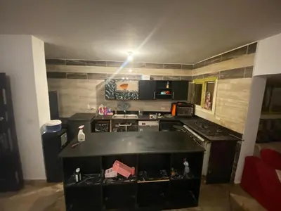 a kitchen with a black counter top and a stove at 2-Room Apartment with Swimming Pool in Hurghada