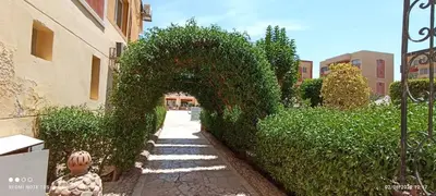 an ivy covered archway next to a building at 2-Room Apartment with Swimming Pool in Hurghada
