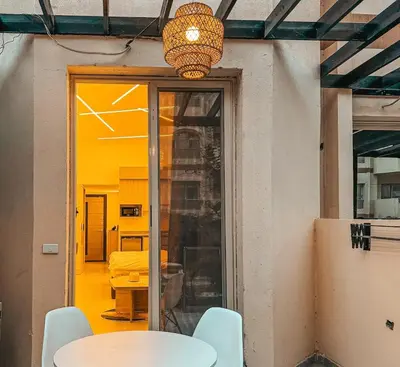 a room with a table and chairs and a light at Arabia FANTA SEA - Stylish Pool Level Studio in Florenza Hrg in Hurghada