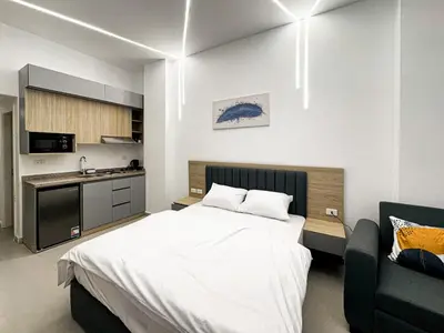 a bedroom with a large bed and a kitchen at Arabia FANTA SEA - Stylish Pool Level Studio in Florenza Hrg in Hurghada