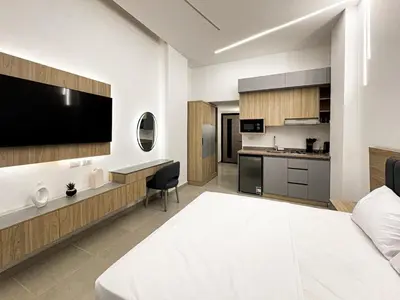 a bedroom with a large bed and a kitchen at Arabia FANTA SEA - Stylish Pool Level Studio in Florenza Hrg in Hurghada