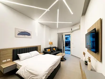 a bedroom with a bed and a couch and a tv at Arabia FANTA SEA - Stylish Pool Level Studio in Florenza Hrg in Hurghada