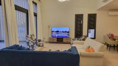 a living room with couches and a flat screen tv at Elgouna -4 bedroom villa with private heated pool in Hurghada