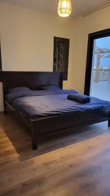 a bedroom with a large bed with a wooden headboard at Elgouna -4 bedroom villa with private heated pool in Hurghada