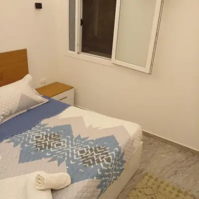 a bedroom with a bed with a window and a mirror at Amazing 1 bedroom & sofa bed at Selenabay Hurghada in Hurghada