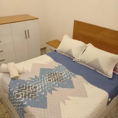 a bedroom with a large bed with a wooden headboard at Amazing 1 bedroom & sofa bed at Selenabay Hurghada in Hurghada