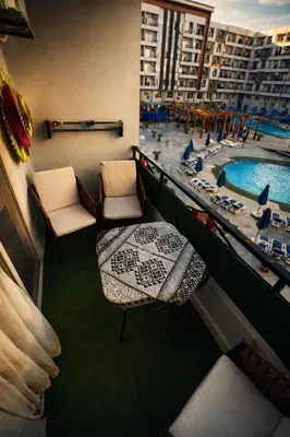 a view of a hotel room with a pool and chairs at Tiba Golden in Hurghada