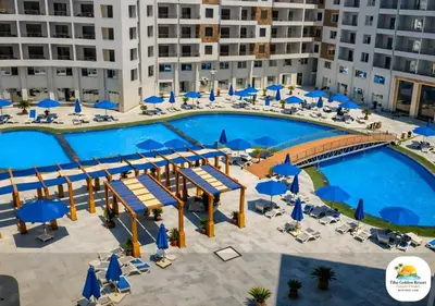 an overhead view of a large swimming pool with blue umbrellas at Tiba Golden in Hurghada