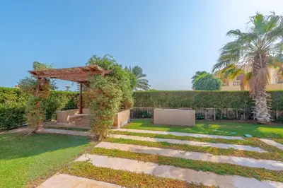 a garden with a stone path and a pergola at VESTA - El Gouna Residence in Hurghada