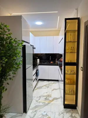 a kitchen with white cabinets and a marble floor at Hurghada - European standard apartment for rent! in Hurghada
