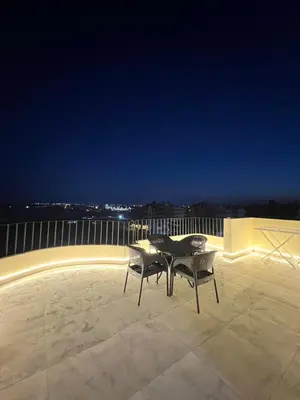 a table and two chairs on a balcony at night at Luxury Sea-View Rooftop with Private Terrace in Hurghada