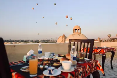 a table with plates of food on top of a roof at Saray El Omda - Egyptian Rural Village in Luxor