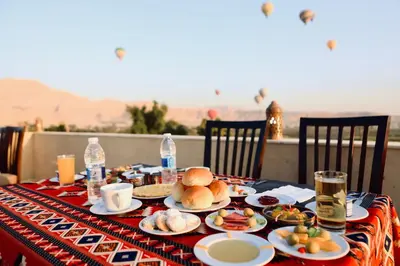 a table with plates of food and water bottles at Saray El Omda - Egyptian Rural Village in Luxor