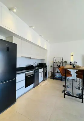 a kitchen with a black refrigerator and a table at The Two Sisters - Kamaran, El Gouna in Hurghada