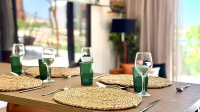 a wooden table with glasses and place settings on it at The Two Sisters - Kamaran, El Gouna in Hurghada