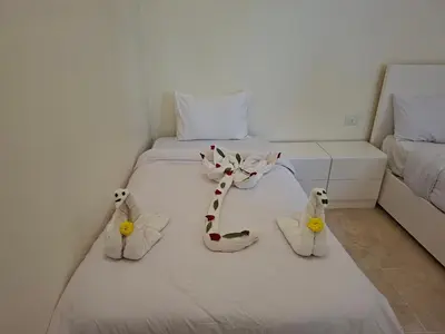 a white bed with two stuffed animals on it at sunrise house in Luxor