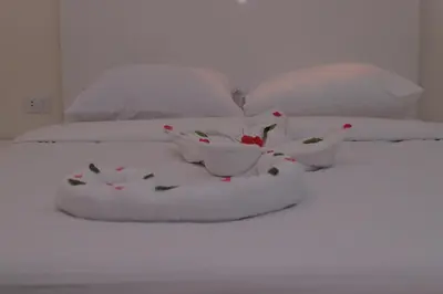a white bed with two bowls and flowers on it at sunrise house in Luxor
