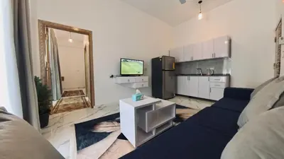 a living room with a blue couch and a kitchen at Luxor Hermes Guest House in Luxor