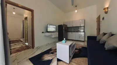 a living room with a blue couch and a kitchen at Luxor Hermes Guest House in Luxor