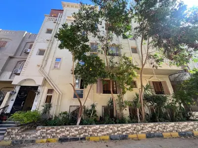 a white building with a tree in front of it at 3 bedroom duplex in Hurghada