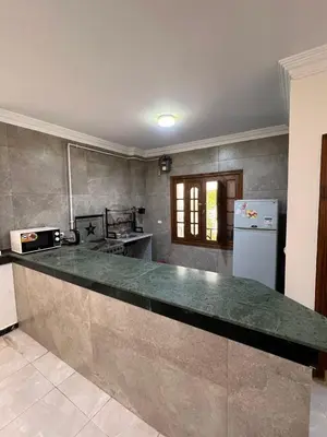 a kitchen with a counter and a refrigerator at 3 bedroom duplex in Hurghada