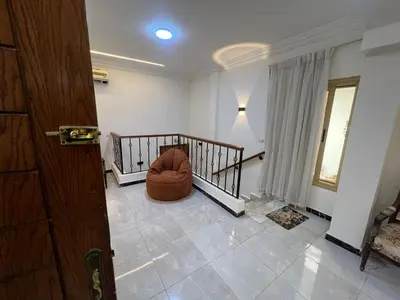 a living room with a chair in the middle of a room at 3 bedroom duplex in Hurghada