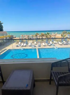 a swimming pool with a view of the ocean at Seaside studio with private Beach and pool in Hurghada