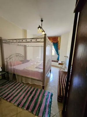 a bedroom with a canopy bed and a rug at Sea-View apartment in El Andalous in Hurghada