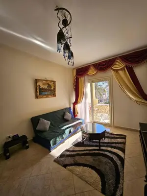 a living room with a couch and a chandelier at Sea-View apartment in El Andalous in Hurghada