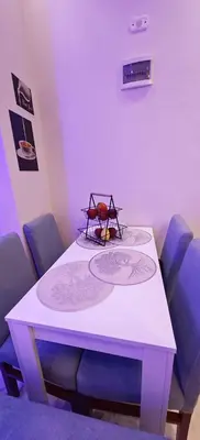 a white table with blue chairs and a plate on it at Ramses Apartment in Hurghada