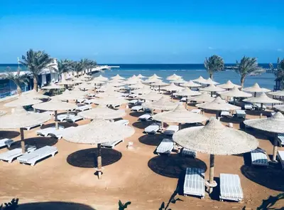 a bunch of umbrellas and chairs on a beach at Nobia Aqua Beach in Hurghada