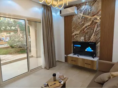 a living room with a tv and a large window at Nobia Aqua Beach in Hurghada