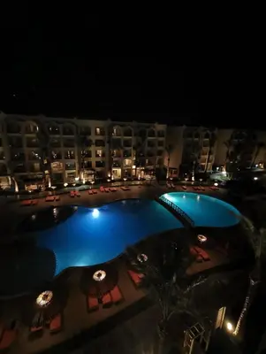 a view of a hotel pool at night at Nobia Aqua Beach in Hurghada